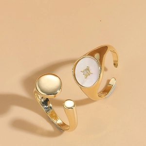 Close-up of golden shell rings featuring an oval mother of pearl with star engraving