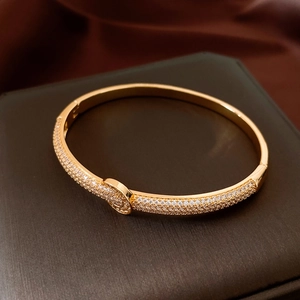 Macro view of 18K gold plated bangle with sparkling micro-pave stones on a jewelry box