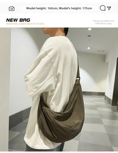 Vue latérale du sac croissant en nylon vert olive porté par un mannequin homme chic