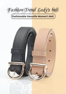 Detail of classic black and beige leather belts featuring polished gold horseshoe buckles