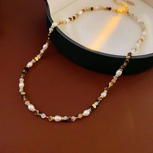 Macro di collana vintage con perle d'acqua dolce e cristalli neri su sfondo pelle