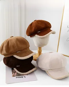 Close-up of suede baker boy hats in four warm colors with plush faux shearling trim details