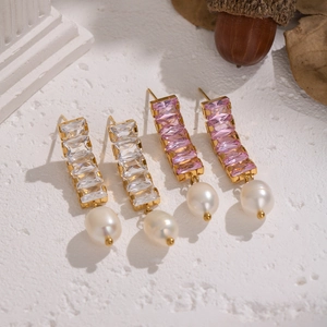 Dettaglio di orecchini placcati oro 18K con zircone quadrato e pendenti in perla