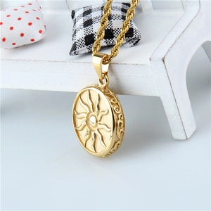 Détail du pendentif soleil plaqué or avec chaîne torsadée sur une chaise en bois blanche