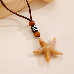 Vue détaillée du pendentif étoile de mer avec perles en bois et cordon en daim brun