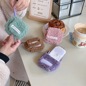 Detail of plush lamb wool mini headphone cases with neck straps in various colors