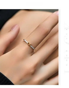Macro detail of slim S925 silver ring with golden heart and micro-pave crystals
