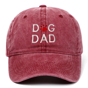 Detailed view of white DOG DAD embroidery on a vintage washed burgundy cotton baseball cap