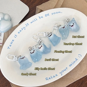 Detail view of light blue translucent jelly ghost charms with white buckles on a white tray