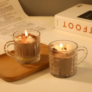 Vertical striped glass scented candles in brown and cream colors on a wooden tray