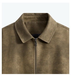 Détail du col d'une veste en similicuir marron olive avec fermeture éclair et texture mate