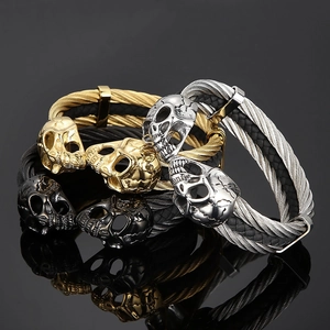 Detailed view of woven leather skull bracelets in gold, silver and gun black finishes