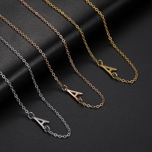 Three minimalist stainless steel letter A necklaces in silver, gold, and rose gold finishes