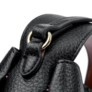 Detailed macro view of black lychee grain leather with shiny gold metal D-ring hardware