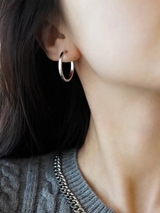 Close-up of minimalist s925 sterling silver hoop earring worn on a model's ear
