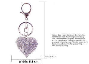Detail of silver heart keychain with crystal rhinestones and decorative bow charm