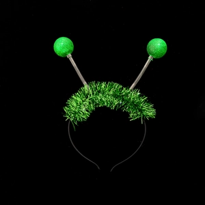 Detail of green alien antenna headband with bouncy glitter balls and metallic tinsel