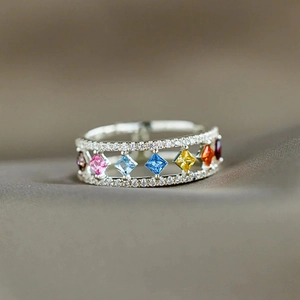 Macro-opname van een zilveren ring met kleurrijke edelstenen en pavé gezette kristallen