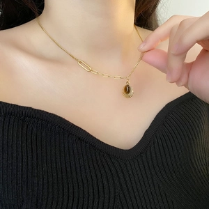 Elegant gold titanium steel necklace with brown tiger eye sunburst pendant on model