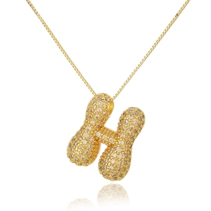 Macro shot of 18k gold plated letter H pendant encrusted with champagne cubic zirconia