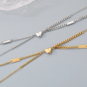 Close-up of gold and silver heart-shaped magnetic clasp on a Cuban chain bracelet