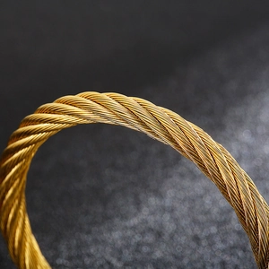 Macro shot of gold punk style twisted wire texture on a stainless steel open cuff bracelet
