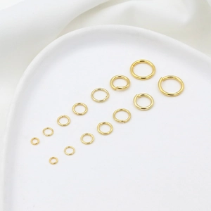 Selection of various sized gold plated jump rings for jewelry making on ceramic dish