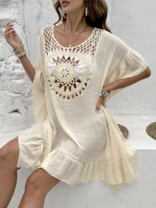 Detail of bohemian crochet hollow-out design and tassel fringe on a beach cover-up dress