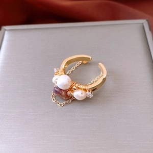 Macro view of 18k gold plated ring featuring pearls and garnet with elegant tassels
