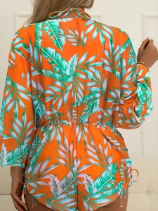 Detail of tropical palm leaf print romper with lace-up back and drawstring sides