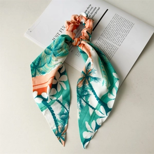 Detailed view of tropical print hair scrunchie with long ribbons on a fashion magazine