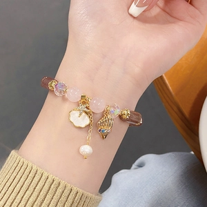 Macro view of beaded bracelet featuring seashell pendants and baroque pearl on wrist
