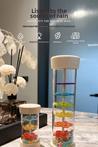 Detail of wooden rainmaker shaker with colorful beads and transparent tube for kids