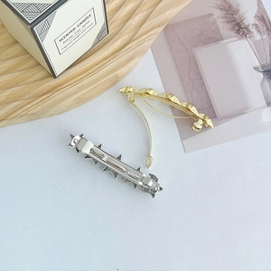 Close-up of the spring clasp mechanism on metal star and bead hair clips