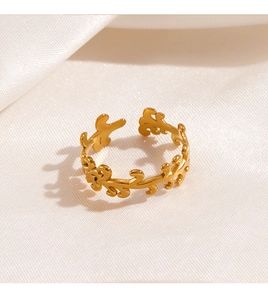 Détail du motif de vigne doré sur une bague réglable en forme de feuille sur fond de soie