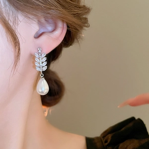 Detailed close-up of zircon wheat ear earrings with elegant pear-shaped drop pearls