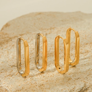 Three pairs of geometric 18K gold-plated stainless steel rectangular earrings on a rock