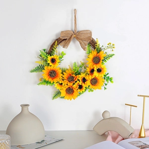 Artificial sunflower wreath with burlap bow and natural twig base on a white wall decor