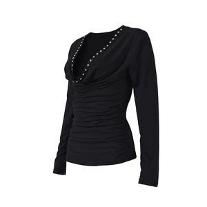 Detail of black slim fit long sleeve top with deep V-neck and metallic rivet accents