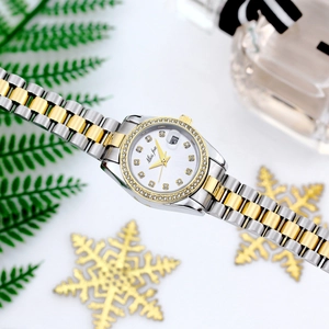 Detail of gold-silver quartz watch featuring a crystal bezel and floral background