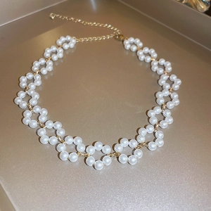 Detail of gold-plated pearl necklace with zircon flower cluster on a luxury tray