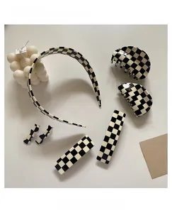 Close-up of a 7-piece black and white checkerboard hair accessory set in acetate material