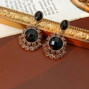 Gros plan de boucles d'oreilles vintage avec cristaux noirs et strass dorés