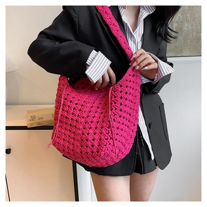 Dettaglio ravvicinato di una grande borsa hobo all'uncinetto rosa con trama in cotone a maglia