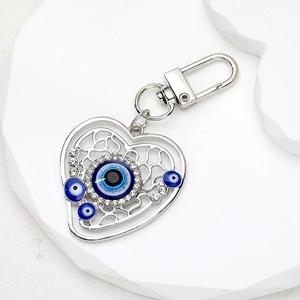Vintage heart-shaped evil eye keychain with blue beads and rhinestones on white background