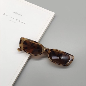 Detailed macro view of tortoiseshell rectangular sunglasses with dark grey lenses