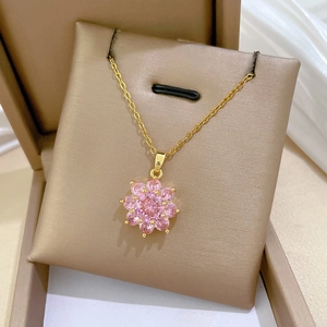 Macro view of flower pendant with pink zircons on a gold-plated titanium steel necklace