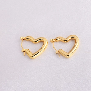 Macro shot of gold heart-shaped hoop earrings with polished stainless steel finish