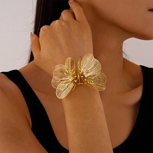 Vue détaillée d'un bracelet manchette ouvert en maille dorée avec fleurs et cristaux