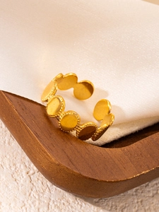 Detailed view of 18k gold plated stainless steel ring with coin pattern on wood